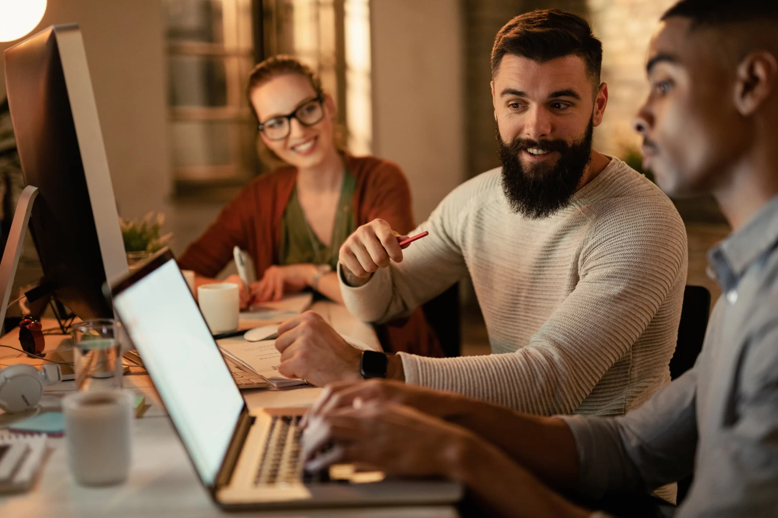 Groupe de développeurs collaborant sur un projet web devant des ordinateurs