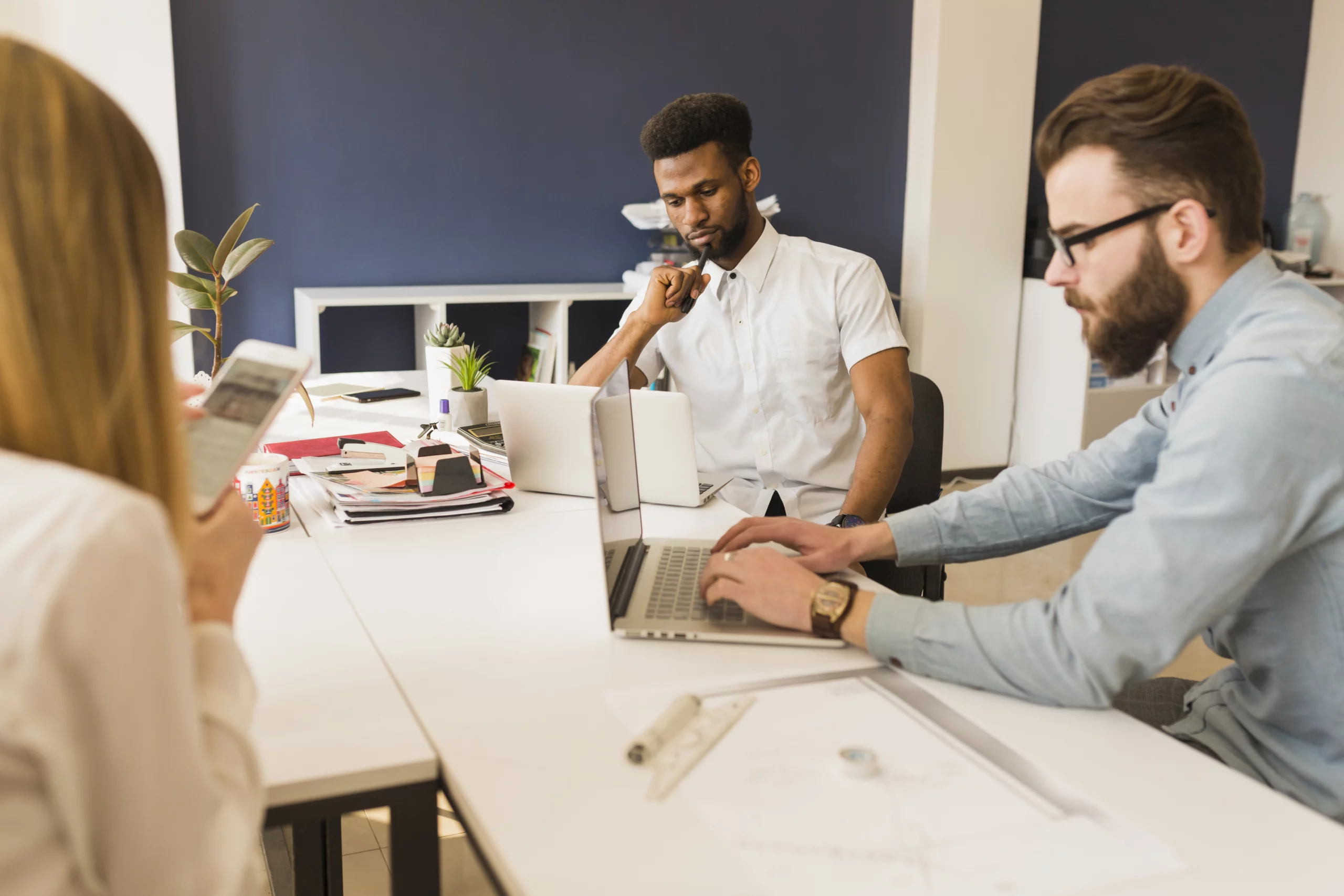 Trois experts en marketing digital travaillant sur une stratégie de contenu dans une agence digitale.