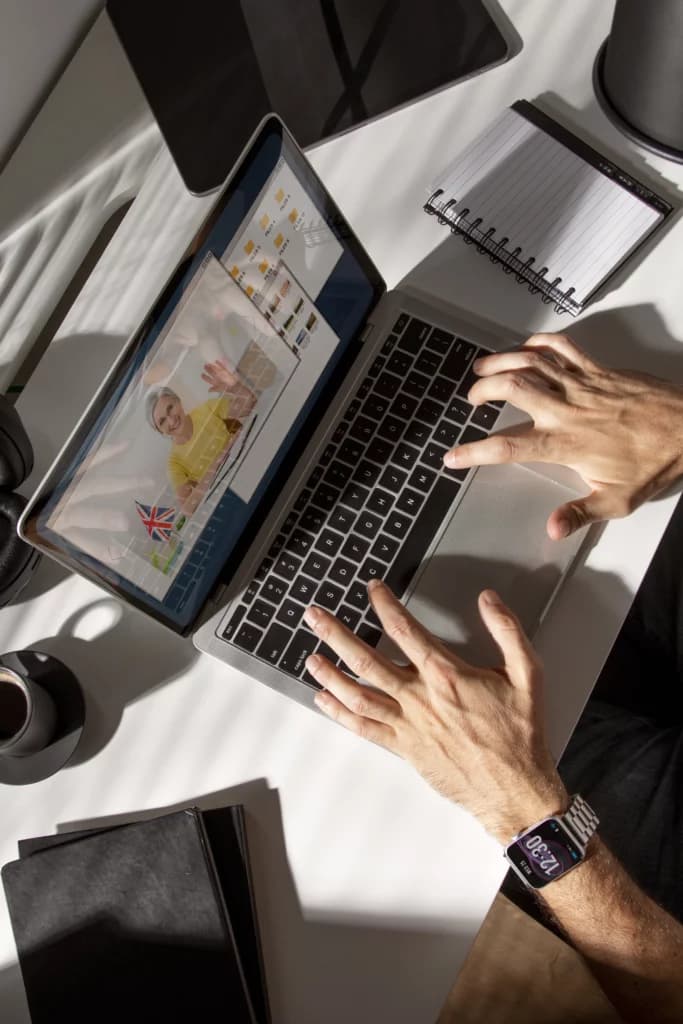 Un professionnel travaillant sur un projet Webflow sur un ordinateur portable, avec des outils créatifs sur le bureau.