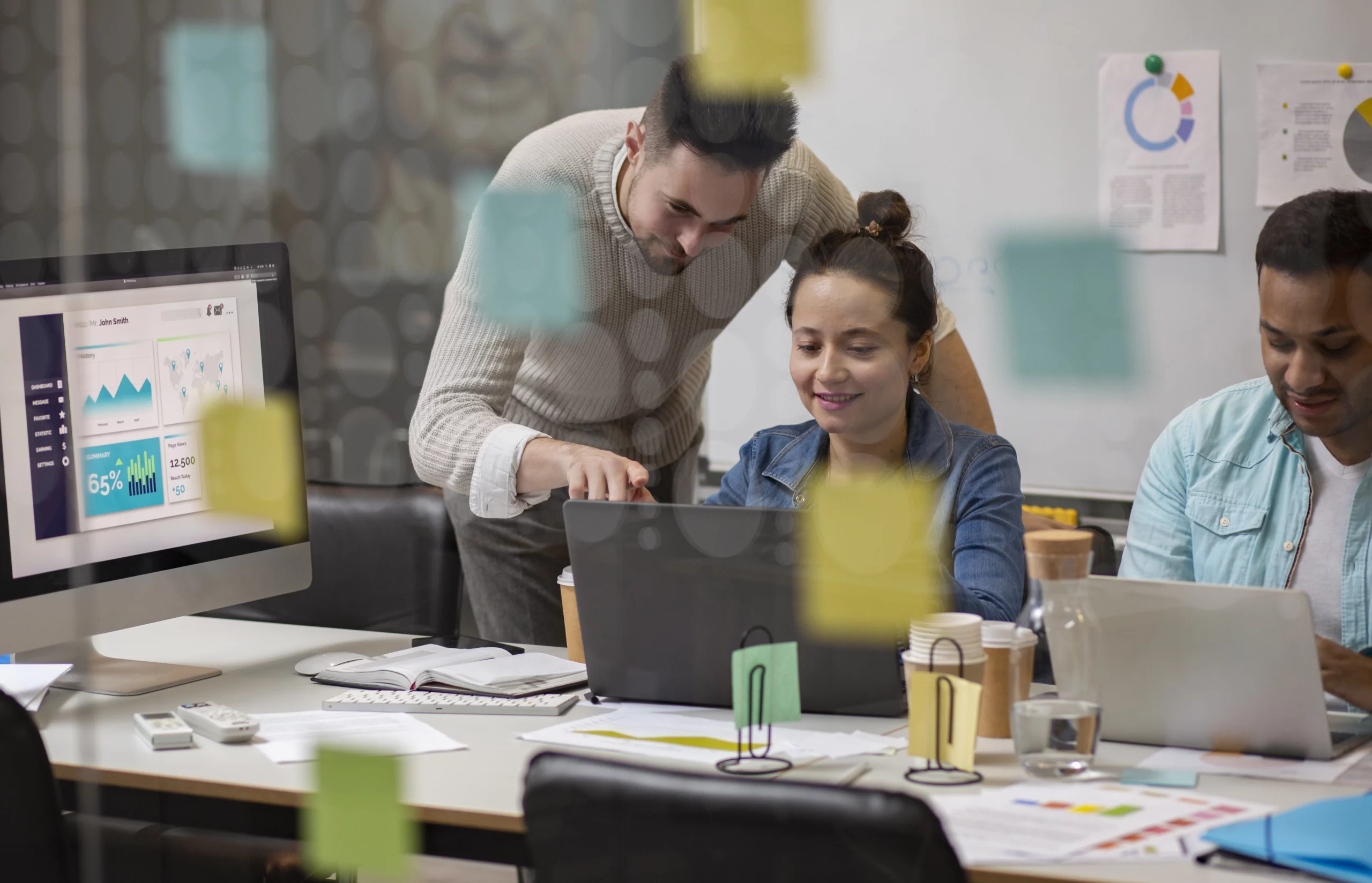 Deux collègues travaillant ensemble sur des solutions de sécurité pour un site web avec des graphiques sur un écran d'ordinateur