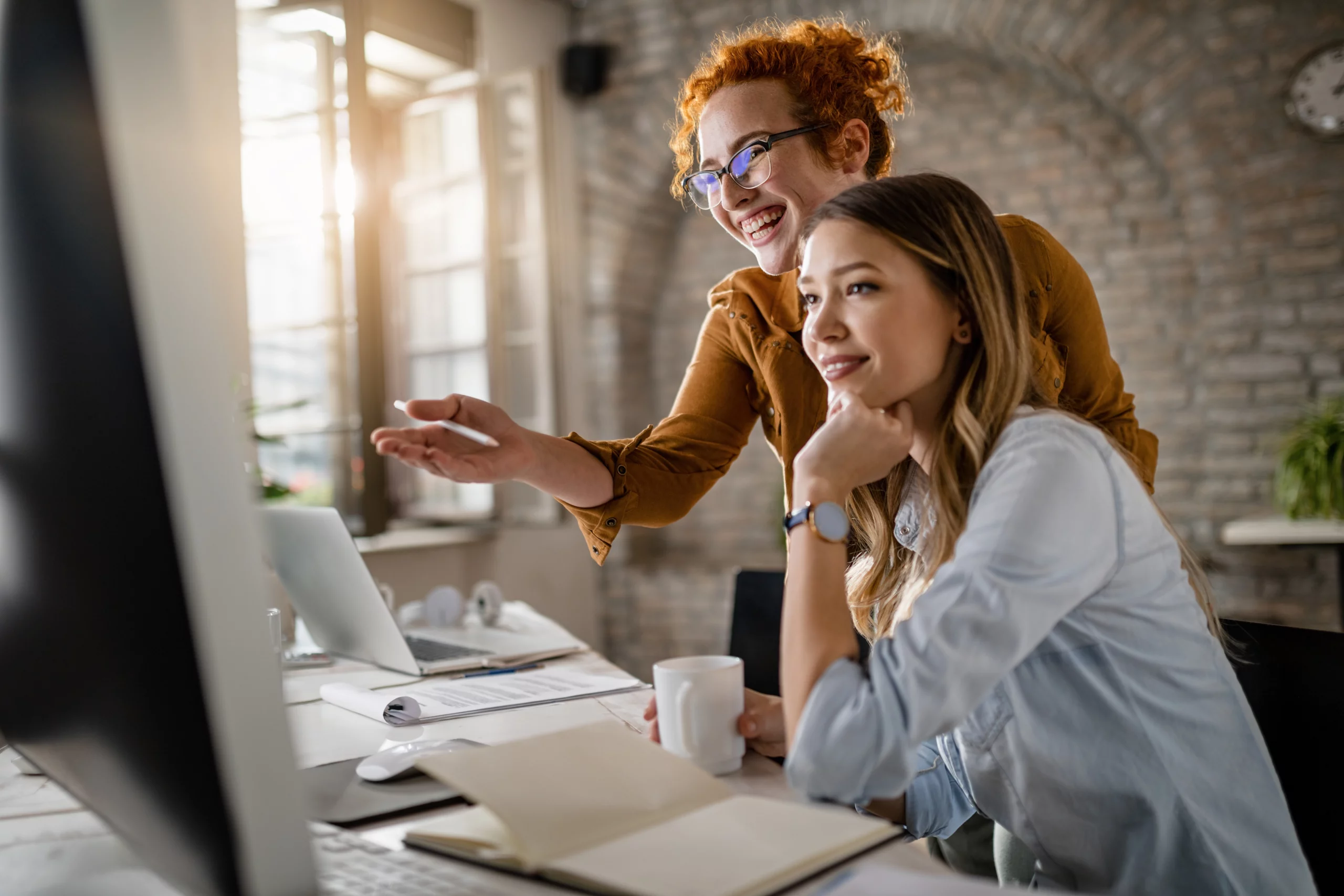 Réunion de travail en agence digitale avec plusieurs collaborateurs utilisant des ordinateurs portables.